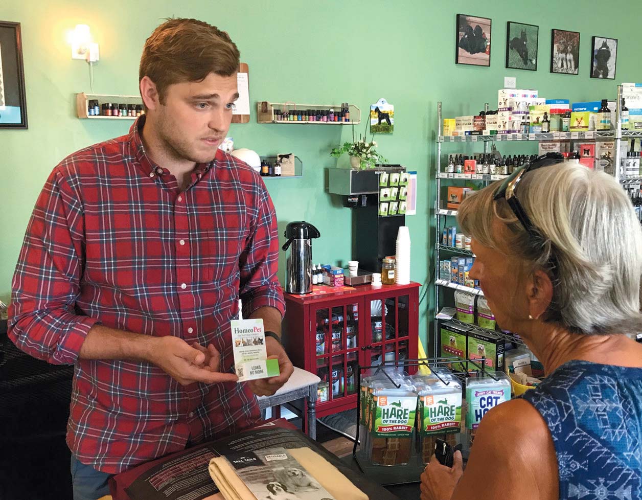 Bryan Schmitt of Cheryl’s Healthy Pet Market explains the benefits of a homeopathic product to customer Joni Ecke.